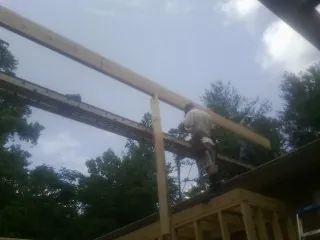 Carpenter setting a ridge beam over a new addition frame — Ice Dam Removal by Roofing Brothers in Minooka