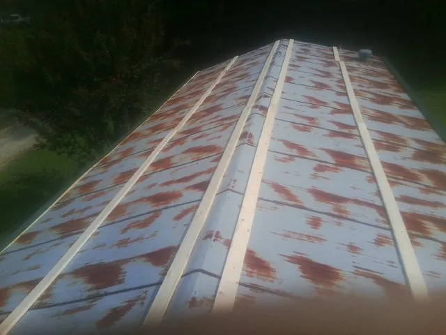 Rusted metal roof panels with new wood purlins before replacement — Storm Damage Roof Repair in Minooka by Roofing Brothers